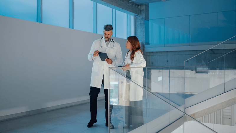 Medical Affairs Professionals Discussing Clinical Data On A Tablet In A Healthcare Office